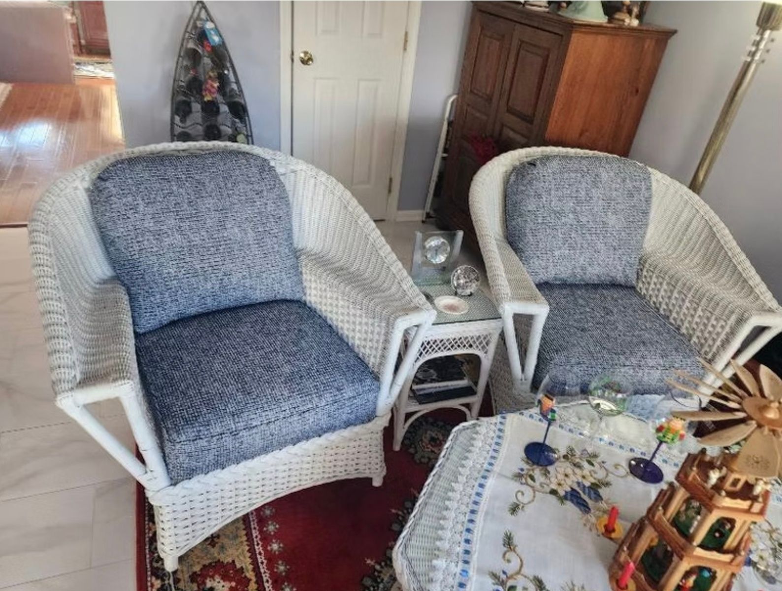 A living room with two wicker chairs and a table