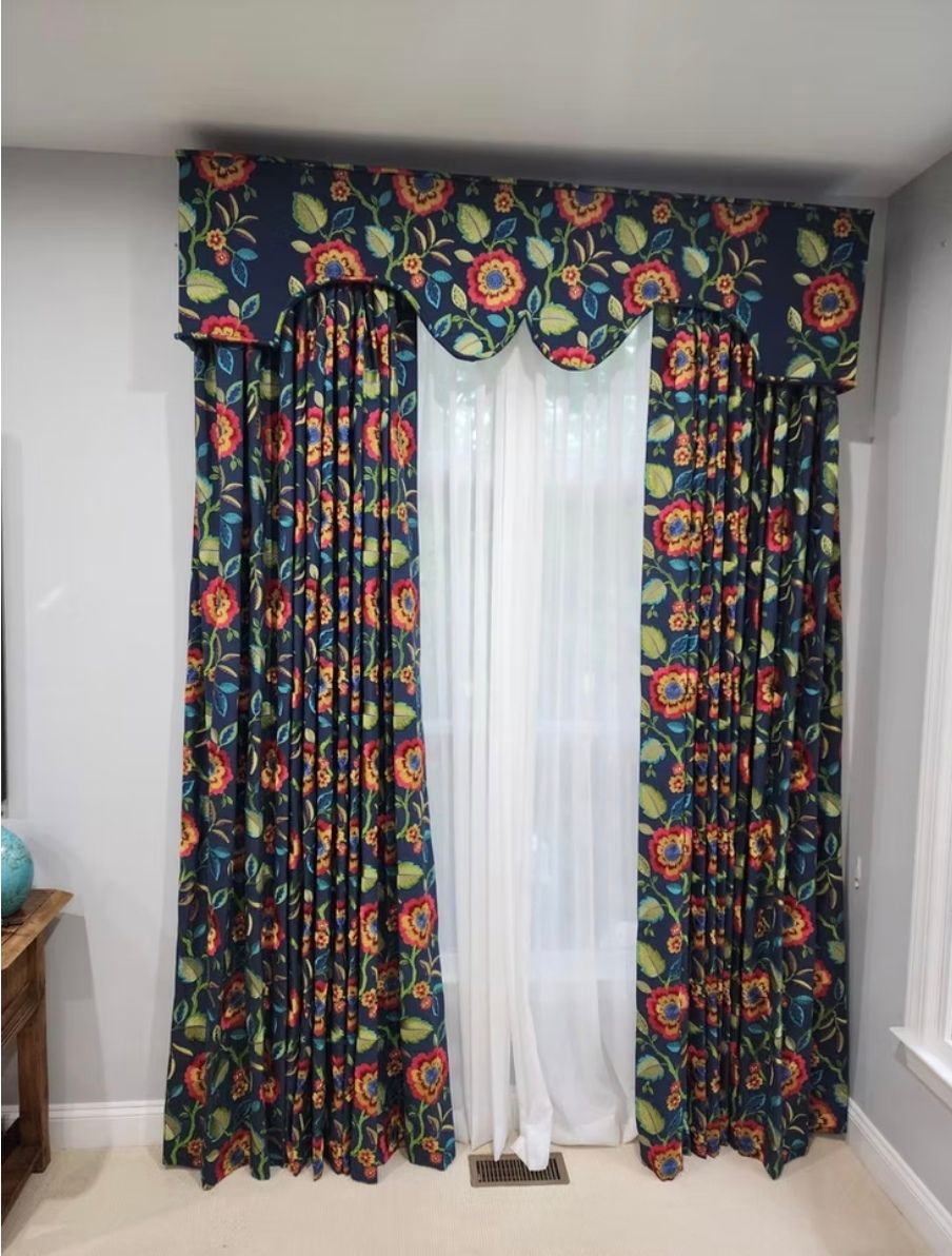 A pair of colorful curtains are hanging on a window in a living room.