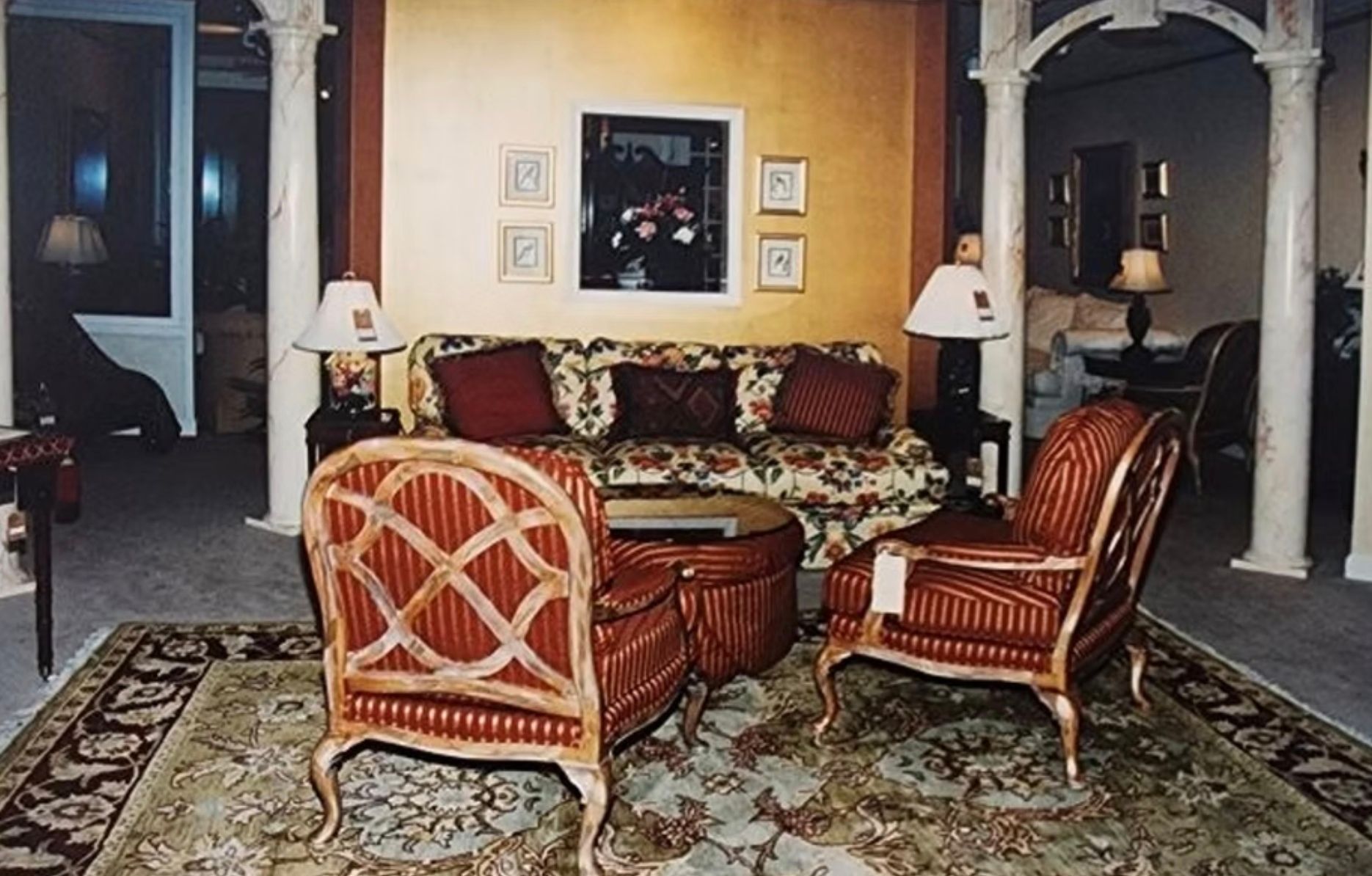 A living room with a couch and chairs and a rug