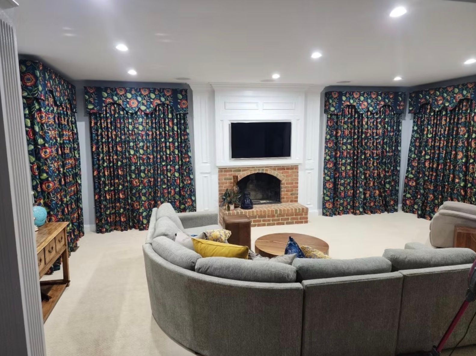 A living room with a couch , fireplace and television.