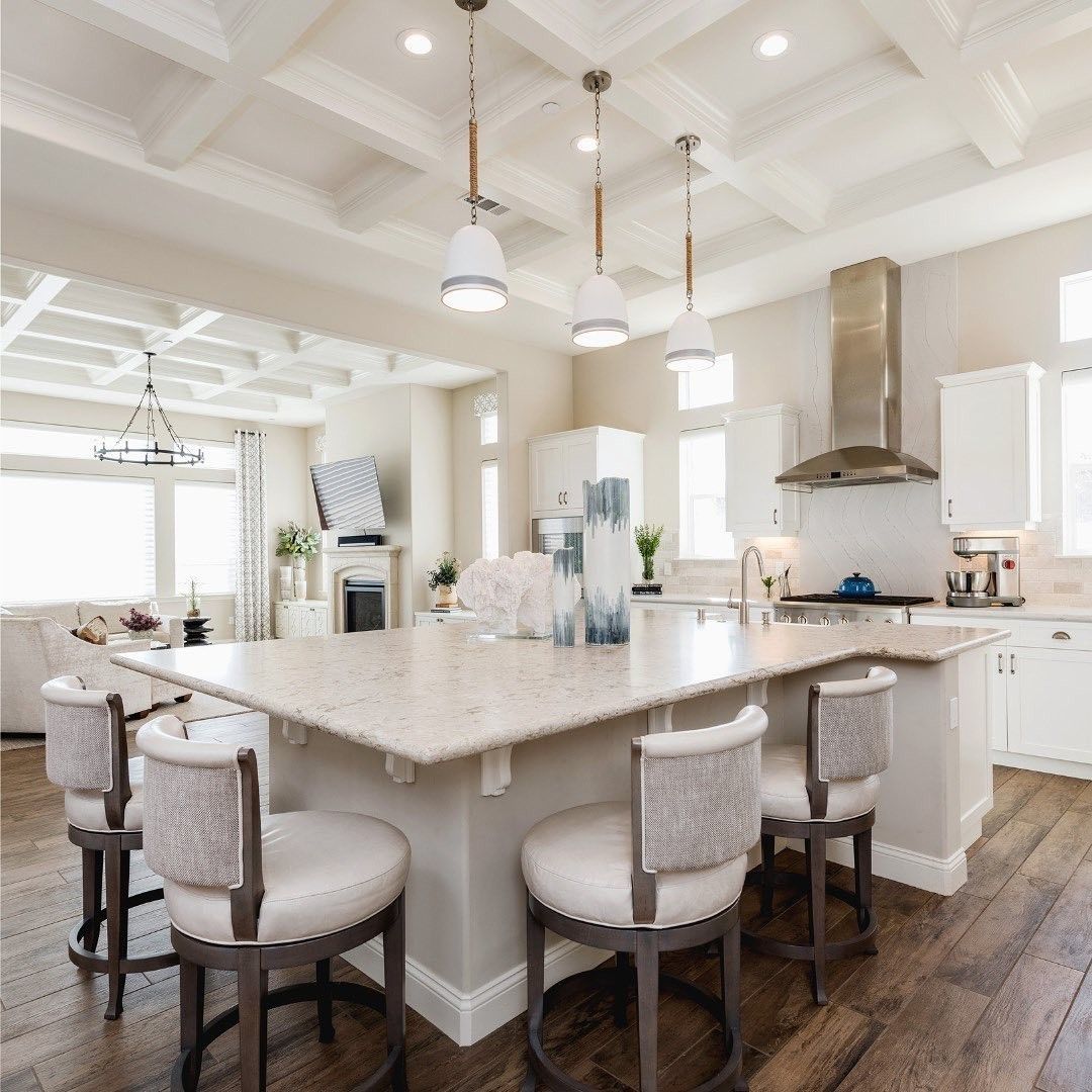 A kitchen with a large island and chairs in it