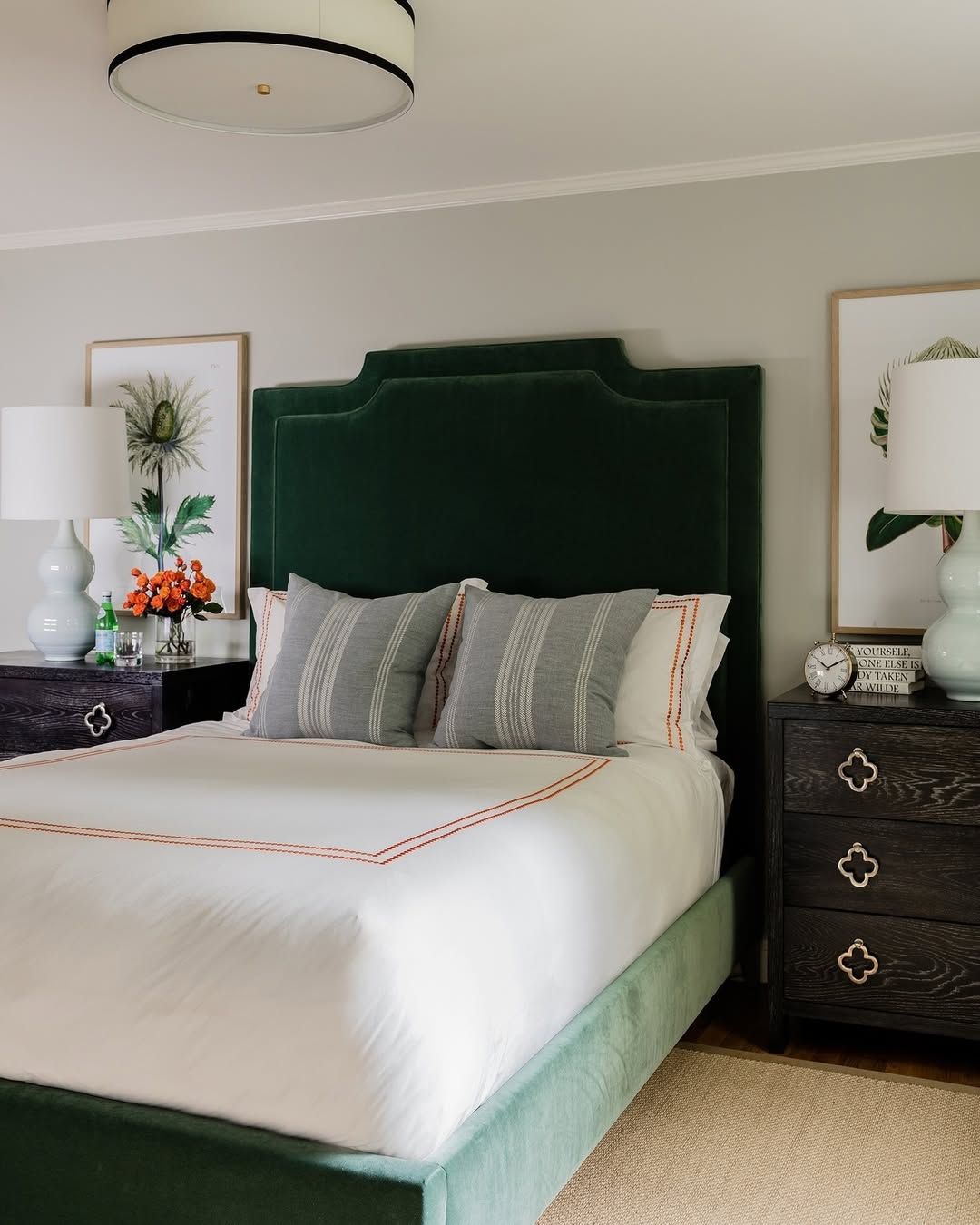 A bedroom with a green headboard and white sheets