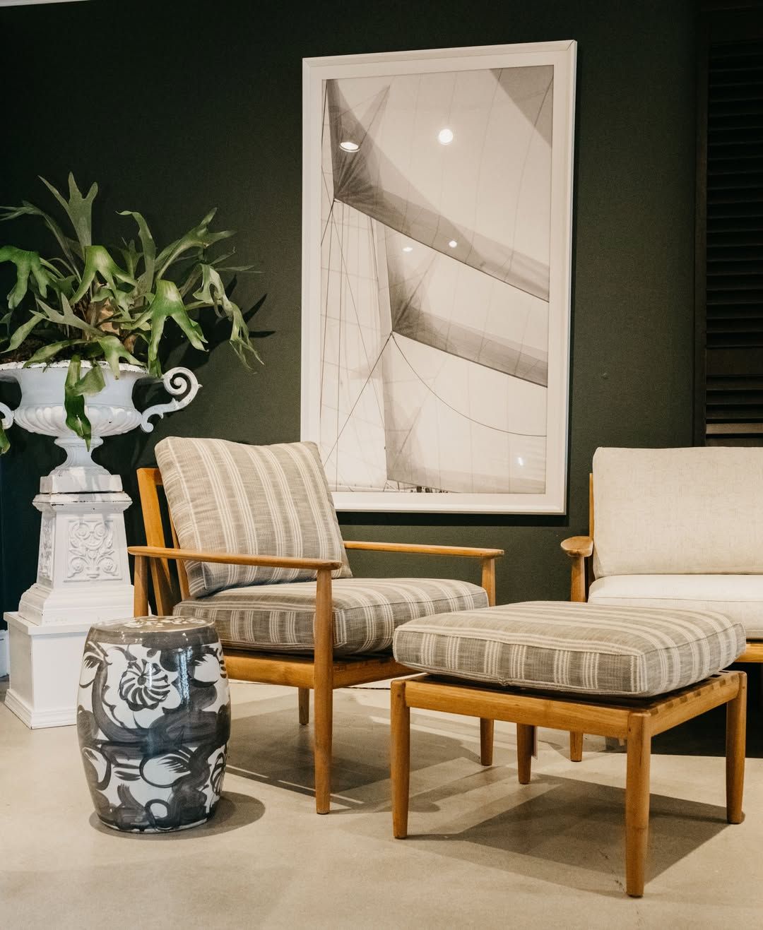 A living room with a couch and chairs and a picture on the wall