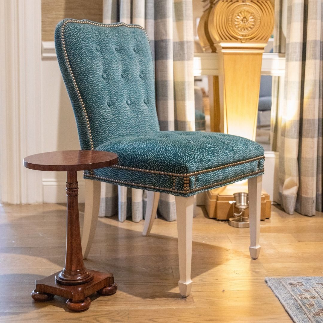 A blue chair is sitting next to a small wooden table