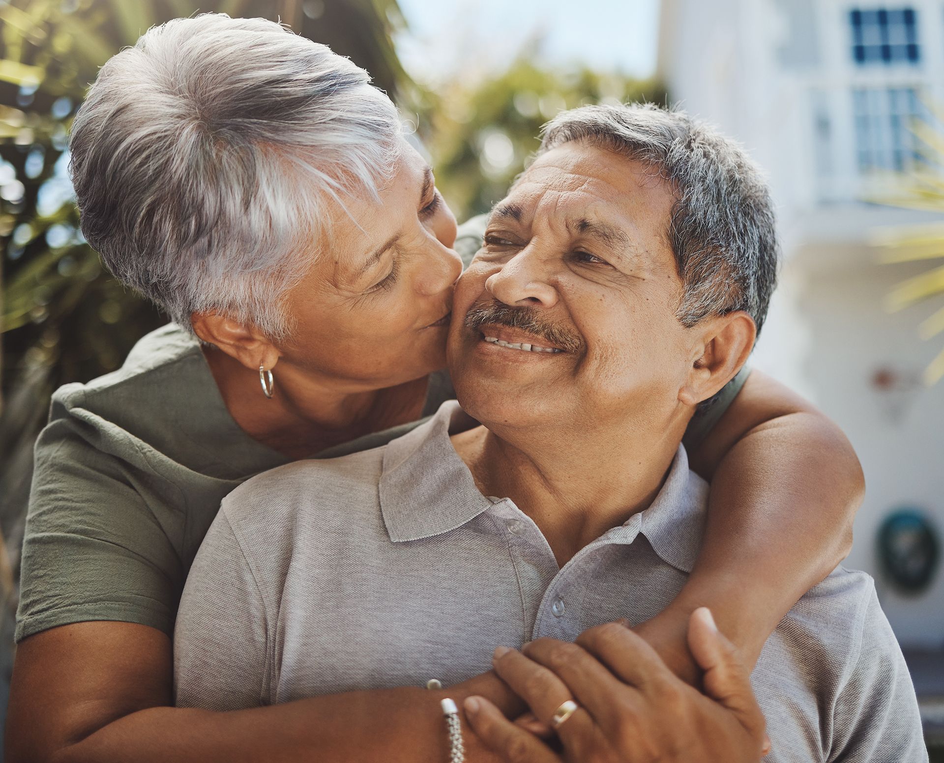 a woman is kissing a man on the cheek .
