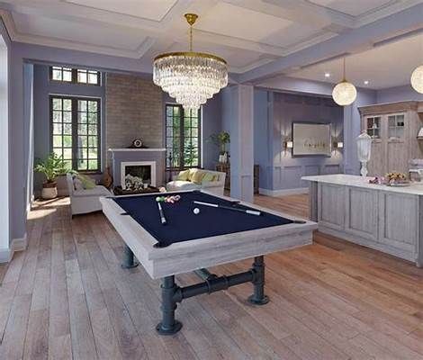 Elegant living room with a pool table, crystal chandelier, fireplace, and adjoining kitchen area
