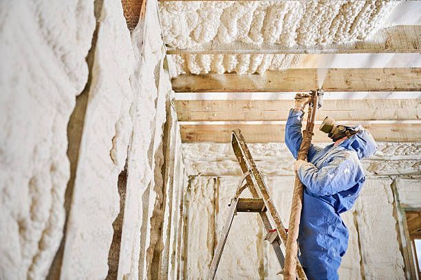 Insulating a basement ceiling with spray foam.