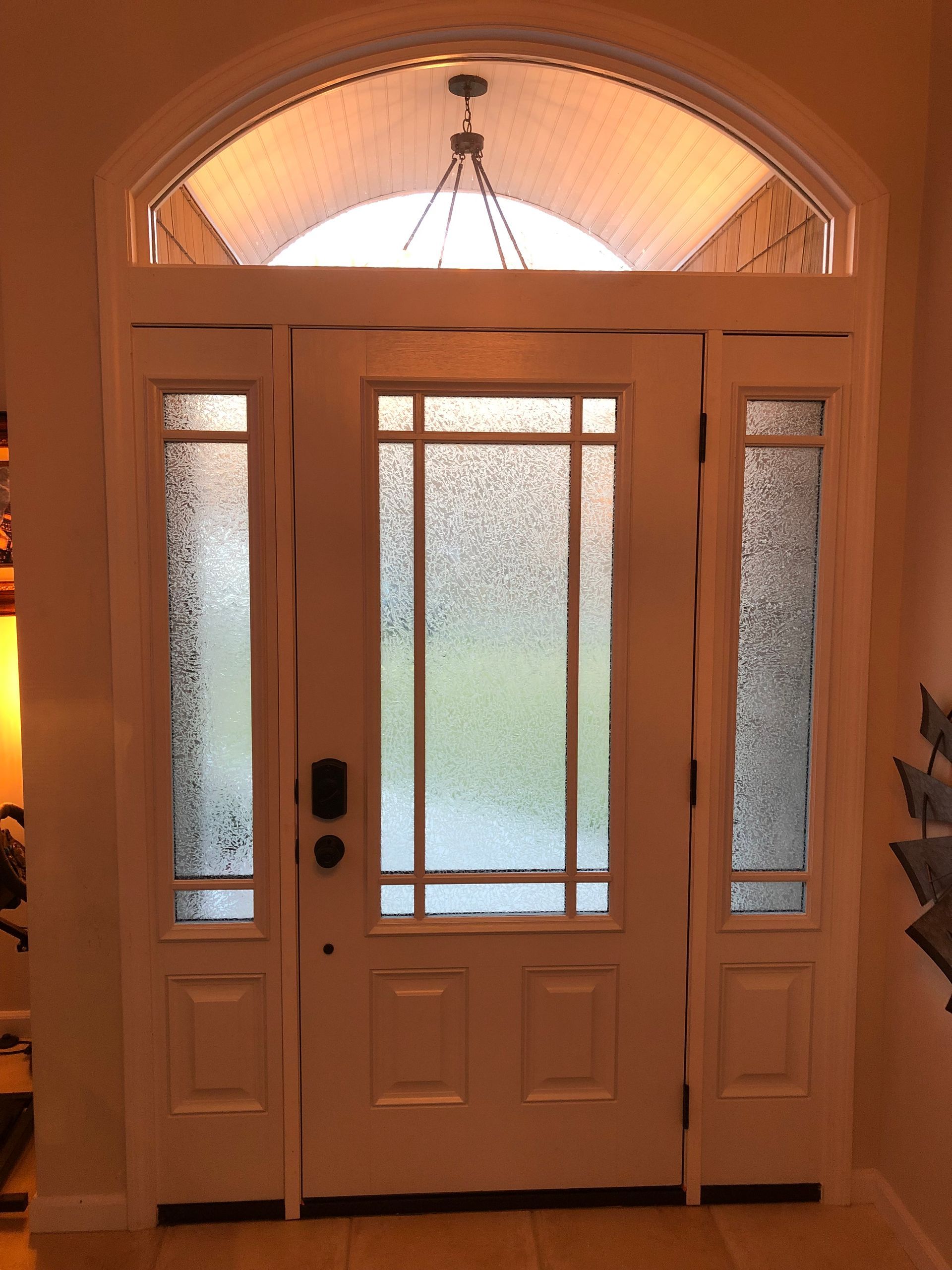 A white door with a chandelier hanging above it