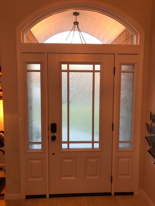 A white door with a chandelier hanging above it