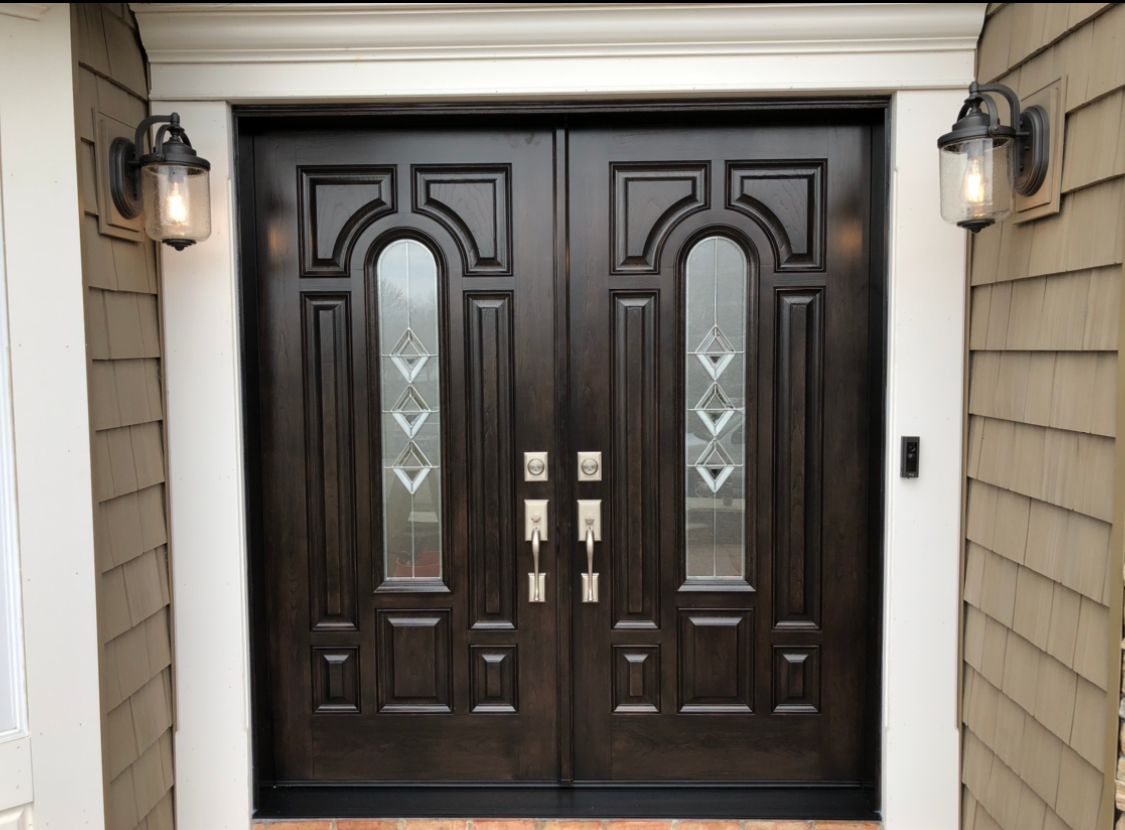 A house with a double door and two lights on the side