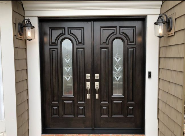 A house with a double door and two lights on the side