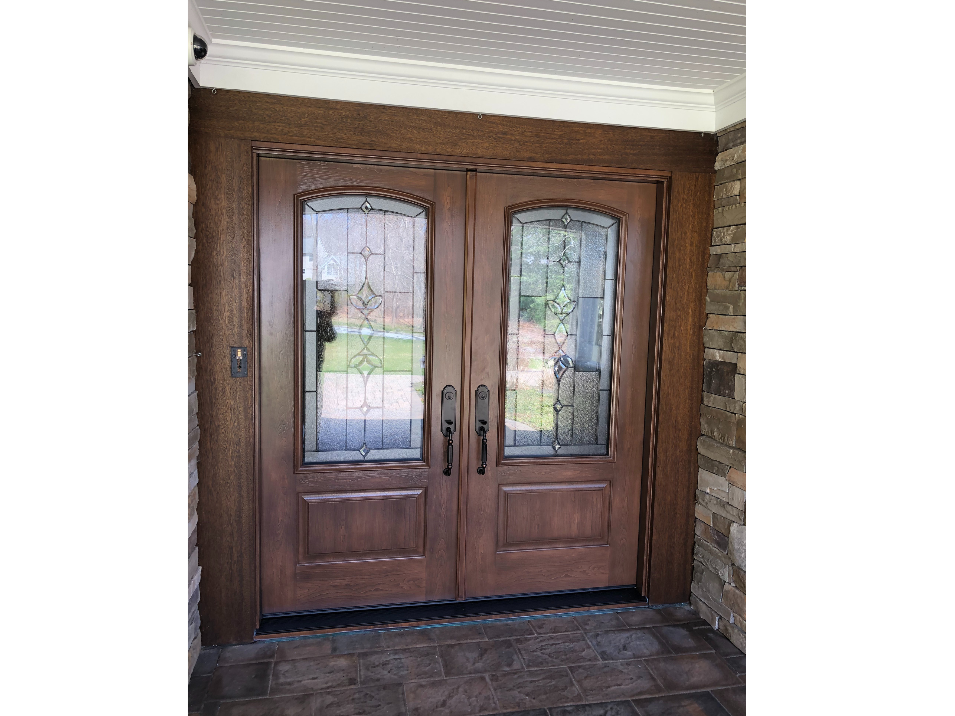 A pair of wooden doors with stained glass windows in a house.