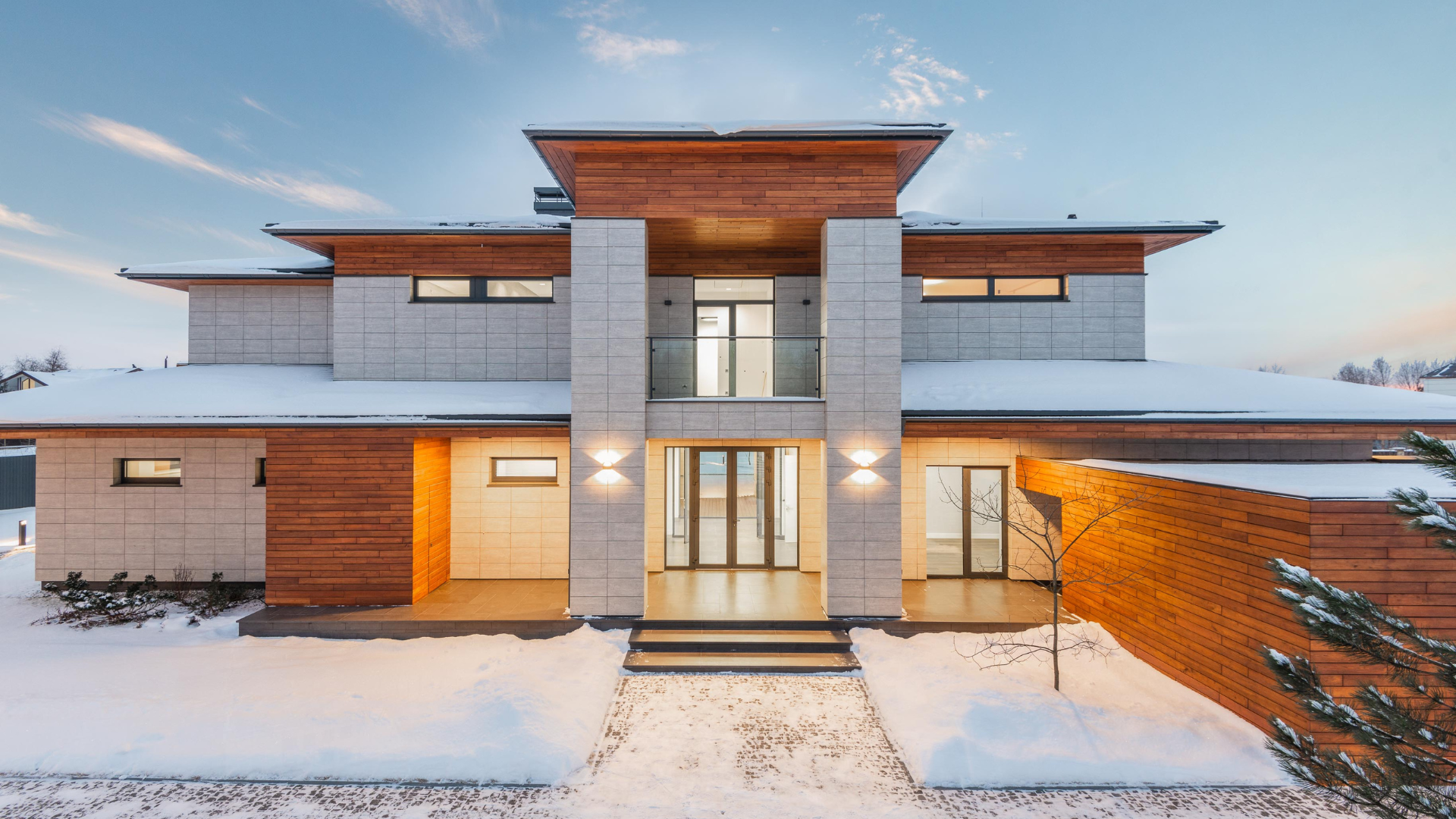 A large house with a lot of windows is covered in snow.