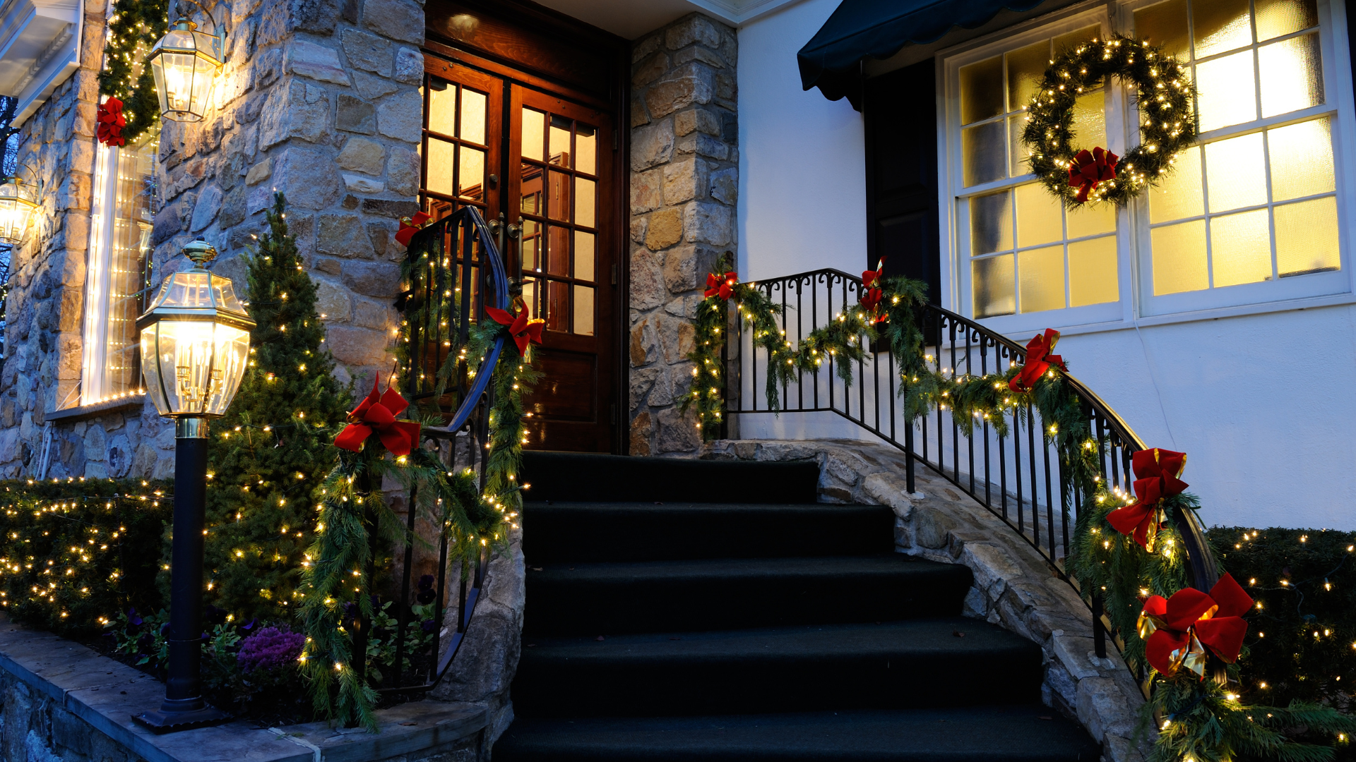 A house is decorated for christmas with christmas lights and trees.