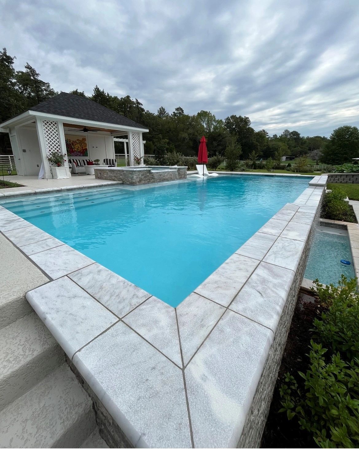 A large swimming pool with a gazebo in the background.