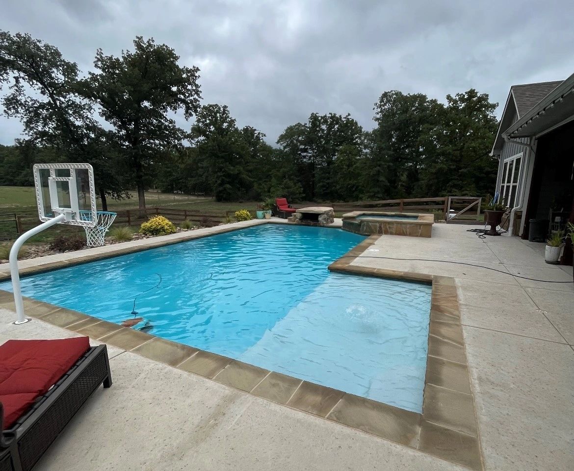 There is a basketball hoop in the middle of the pool.