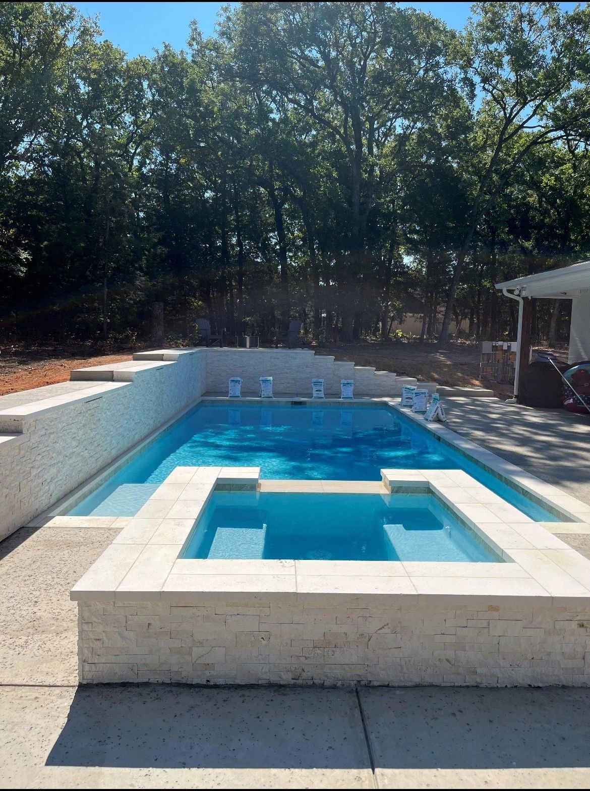 A large swimming pool with a hot tub in the middle