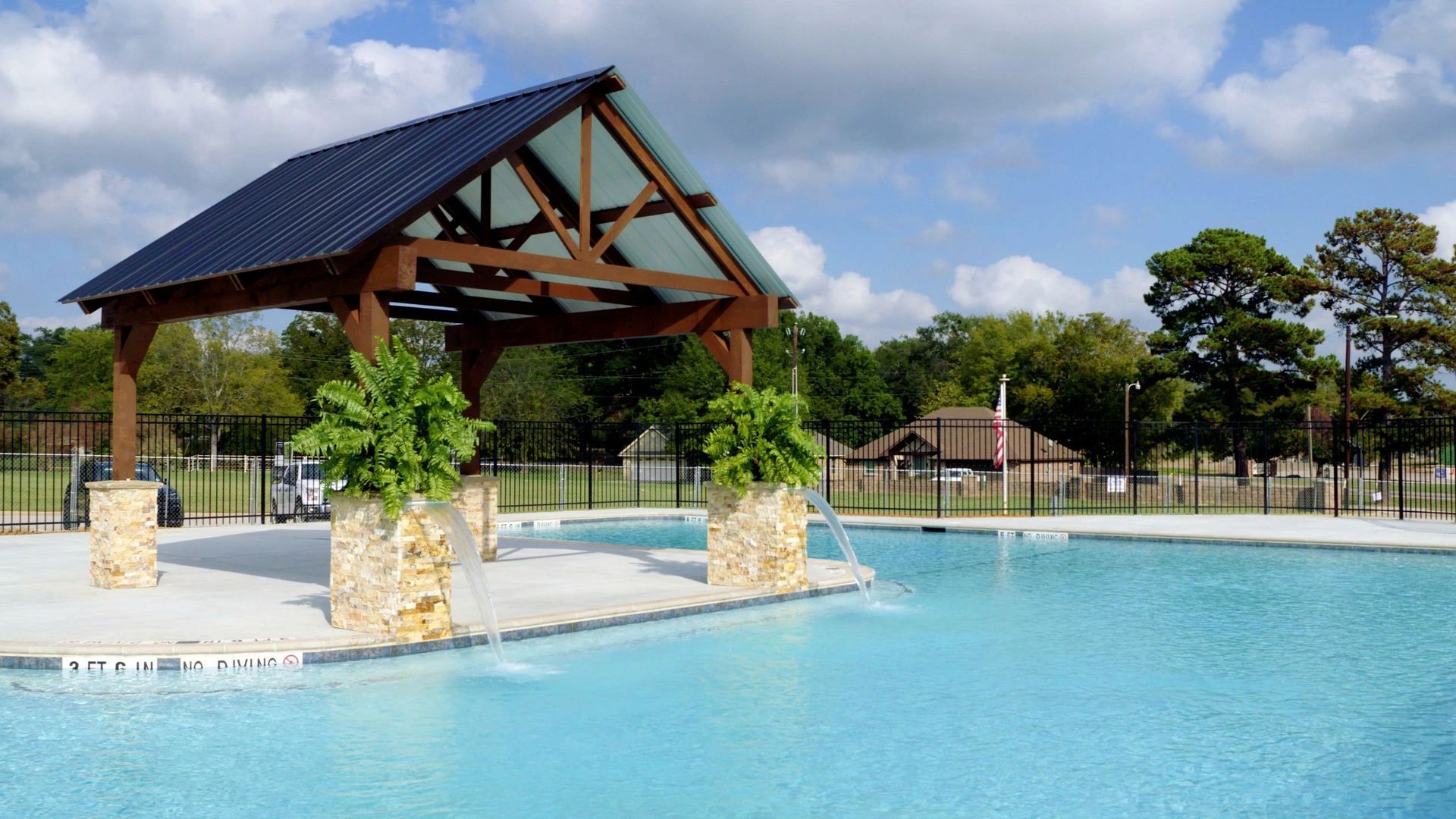 A large swimming pool with a gazebo in the middle of it.