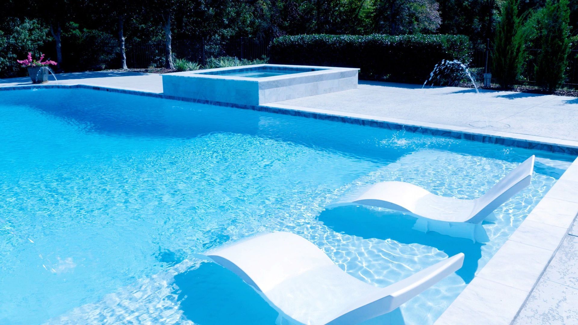 A swimming pool with two white chairs in it
