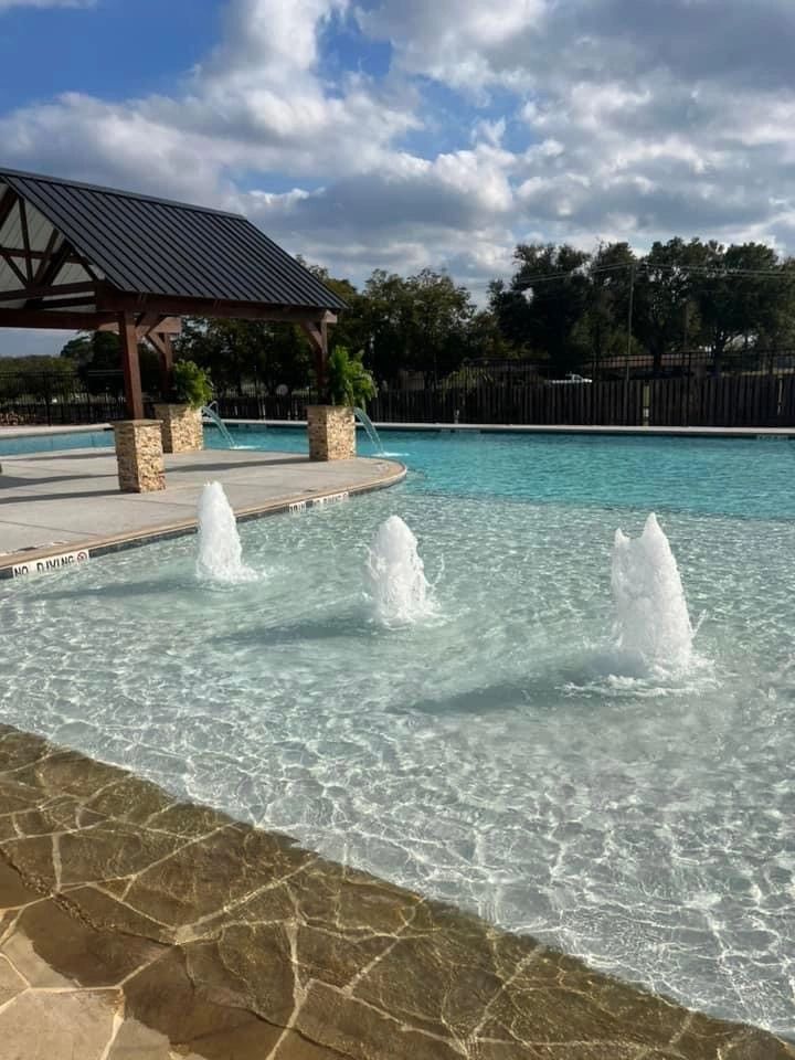 There are three fountains in the middle of the pool.