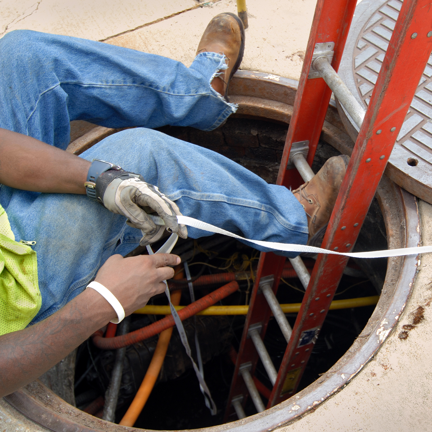 Man Organizing the Cables in A Manhole | Grove City, OH | CST Utilities Man Organizing the Cables in A Manhole | Grove City, OH | CST Utilities