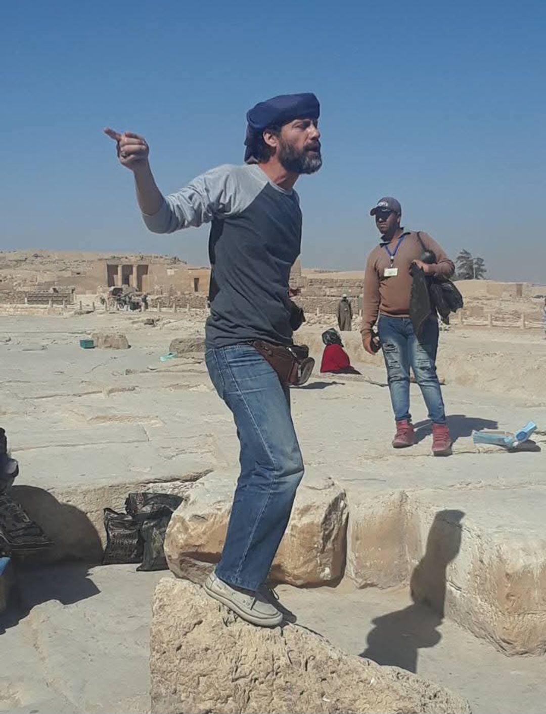 A man standing on a rock pointing at something