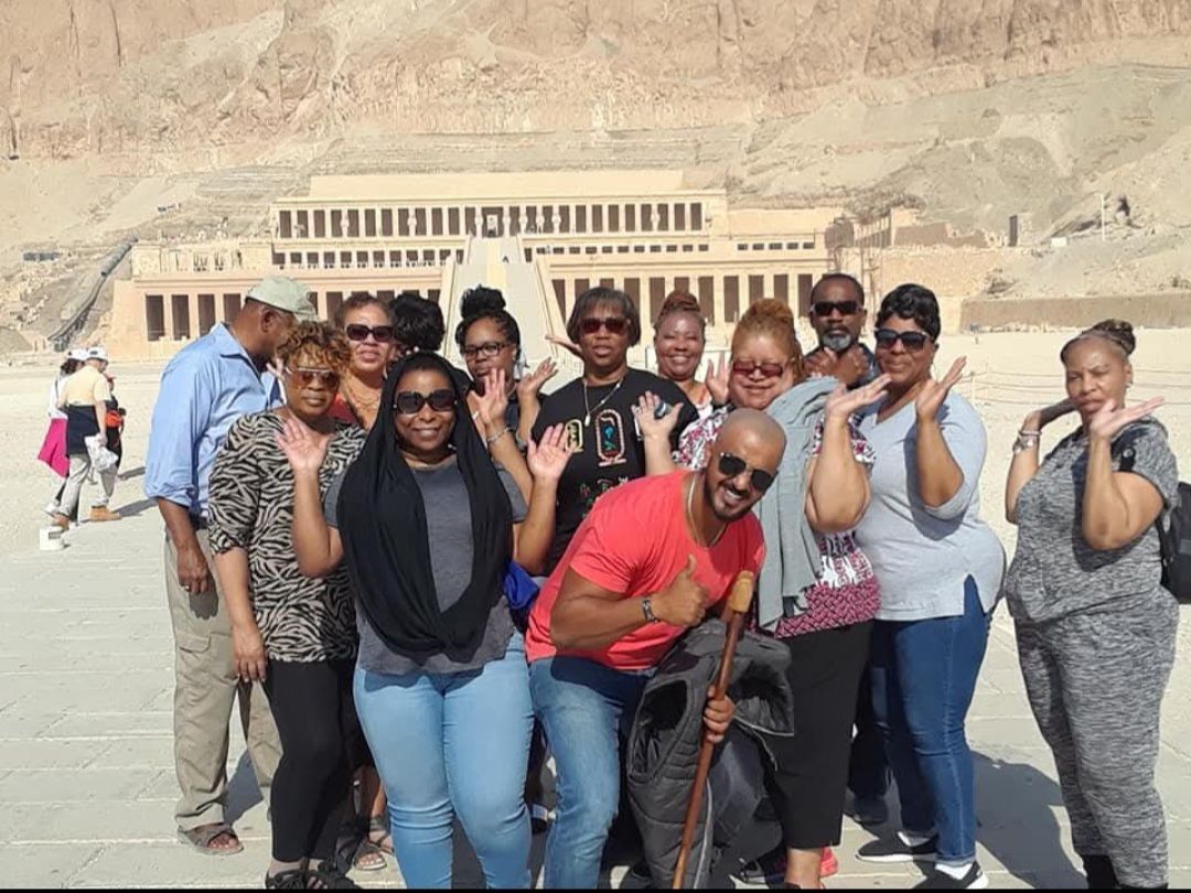 A group of people are posing for a picture in front of a building.