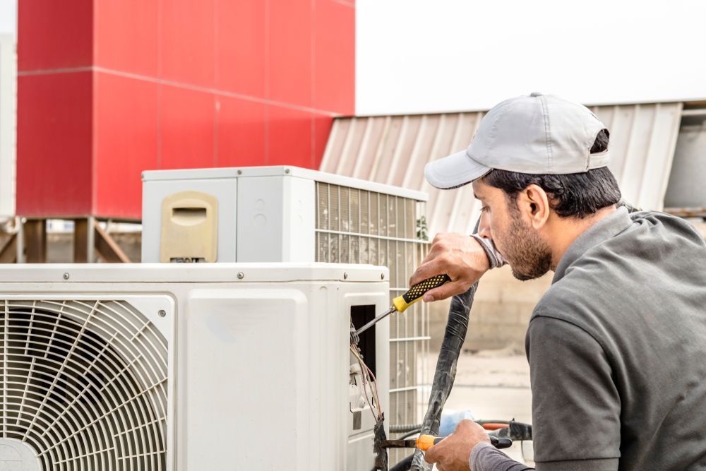 HVAC Technician Repairs an Outdoor Air Conditioning Unit — East Coast Air In Raymond Terrace, NSW