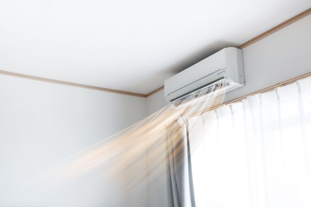 A White Air Conditioner Is Blowing Air Out Of A Window — East Coast Air In East Maitland, NSW
