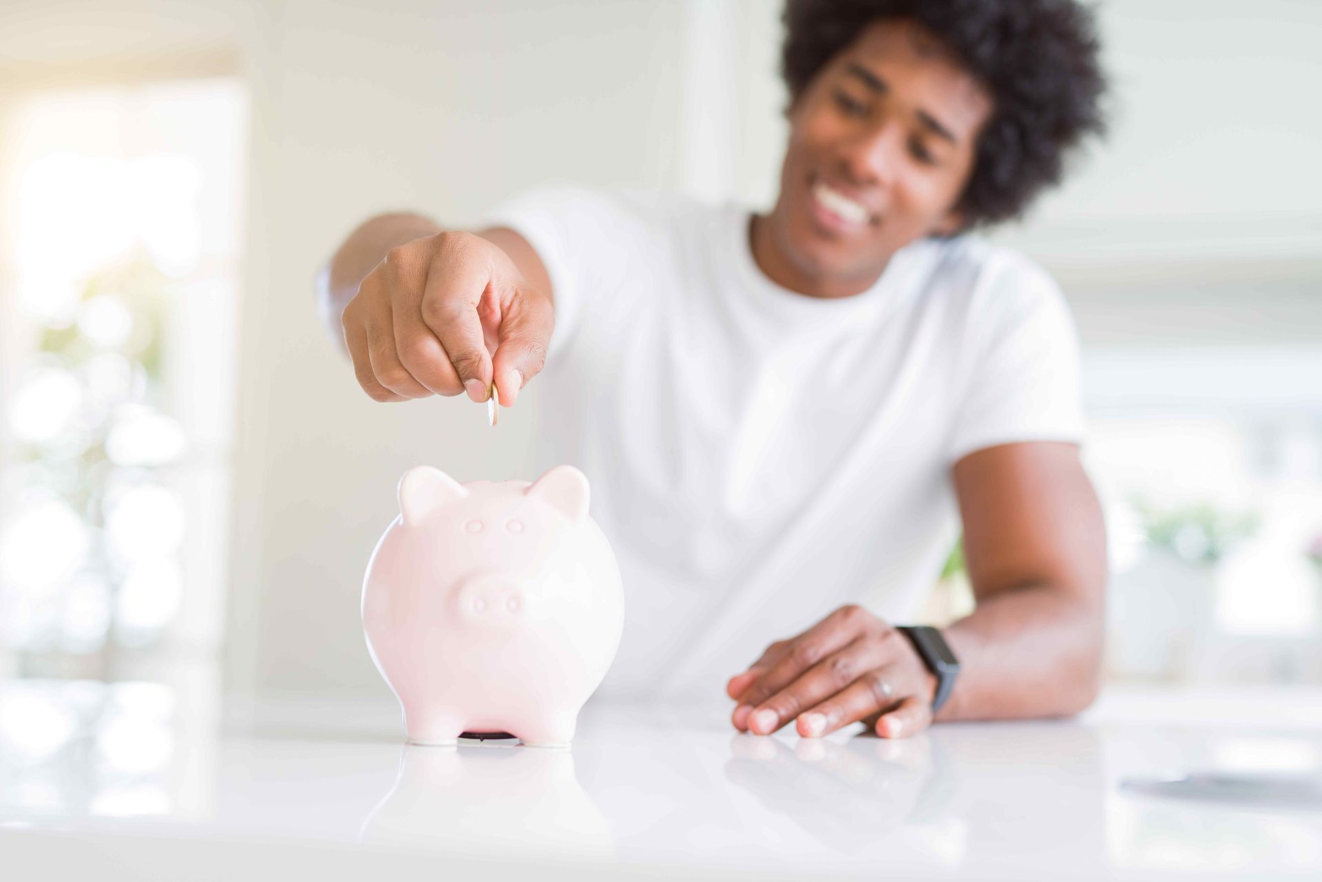A person dropping change into a piggy bank
