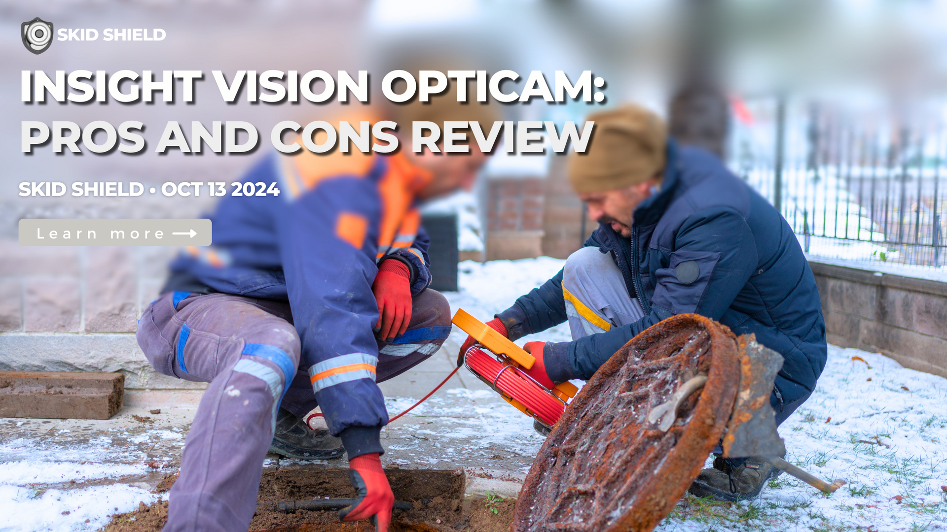 2 sewer inspectors holding a red sewer camera cable reel working next to a sewer