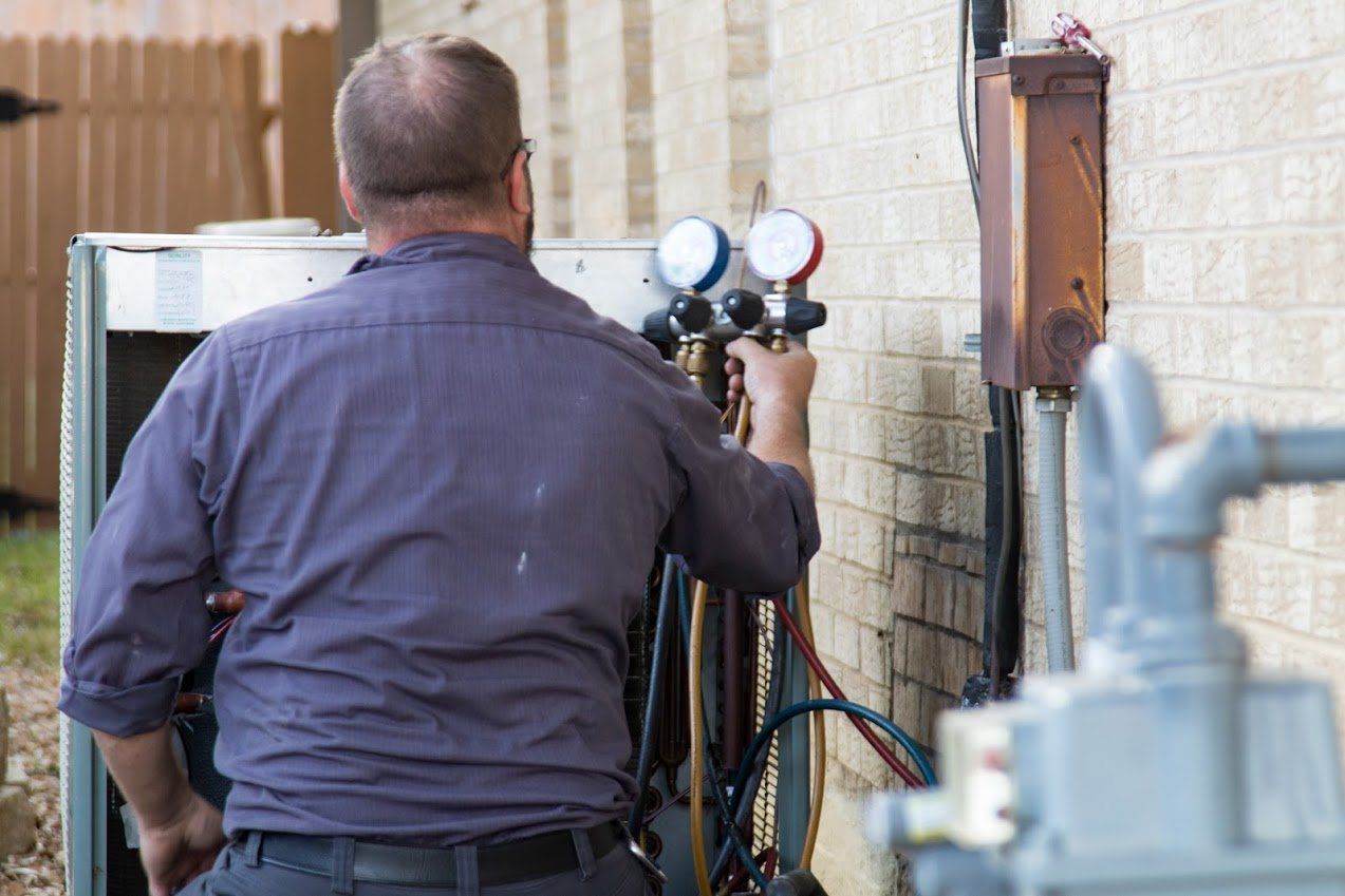Air Conditioning Repair — Man Repairing Aircon in Irving, TX Air Conditioning Repair — Man Repairing Aircon in Irving, TX