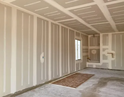 A man is plastering a wall with a spatula.