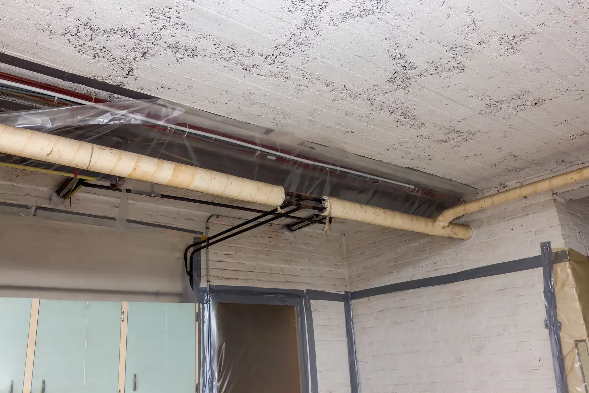 A room with a lot of pipes hanging from the ceiling