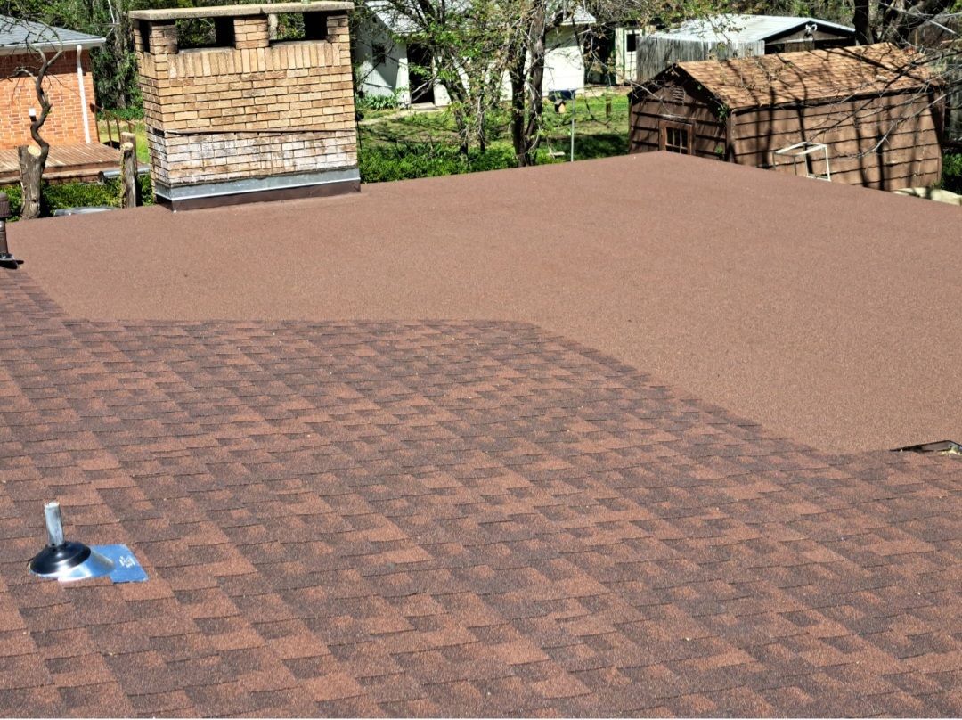 Rooftop with brick paving, tan surface, and small stone structures in the background.