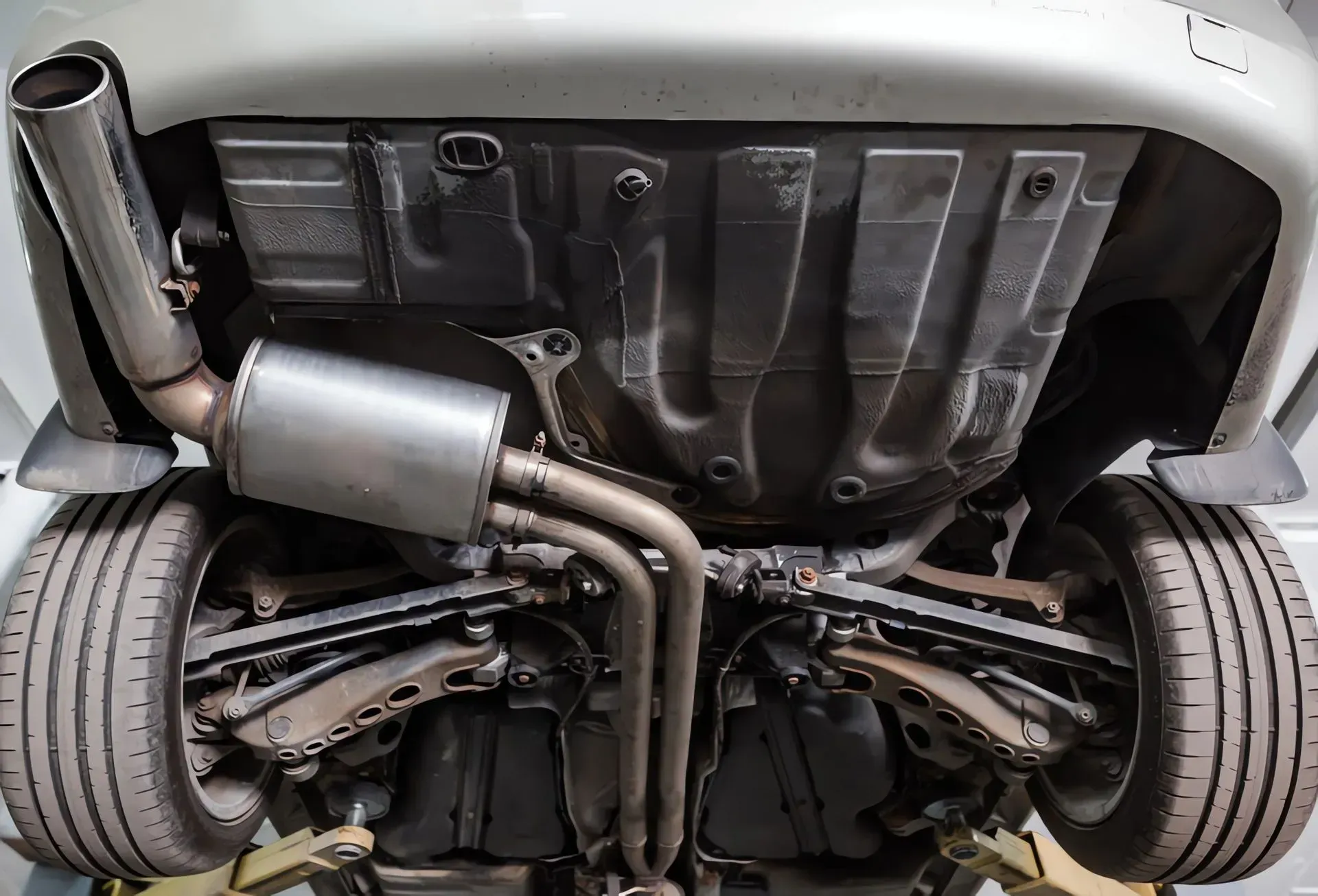 Undercarriage of a White Car, Showing Exhaust System, Suspension — Carline Automotive and Exhausts in Belmont, NSW