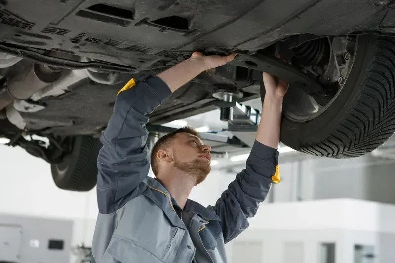 Mechanic Working Under a Car, Inspecting Its Underside — Carline Automotive and Exhausts in Belmont, NSW