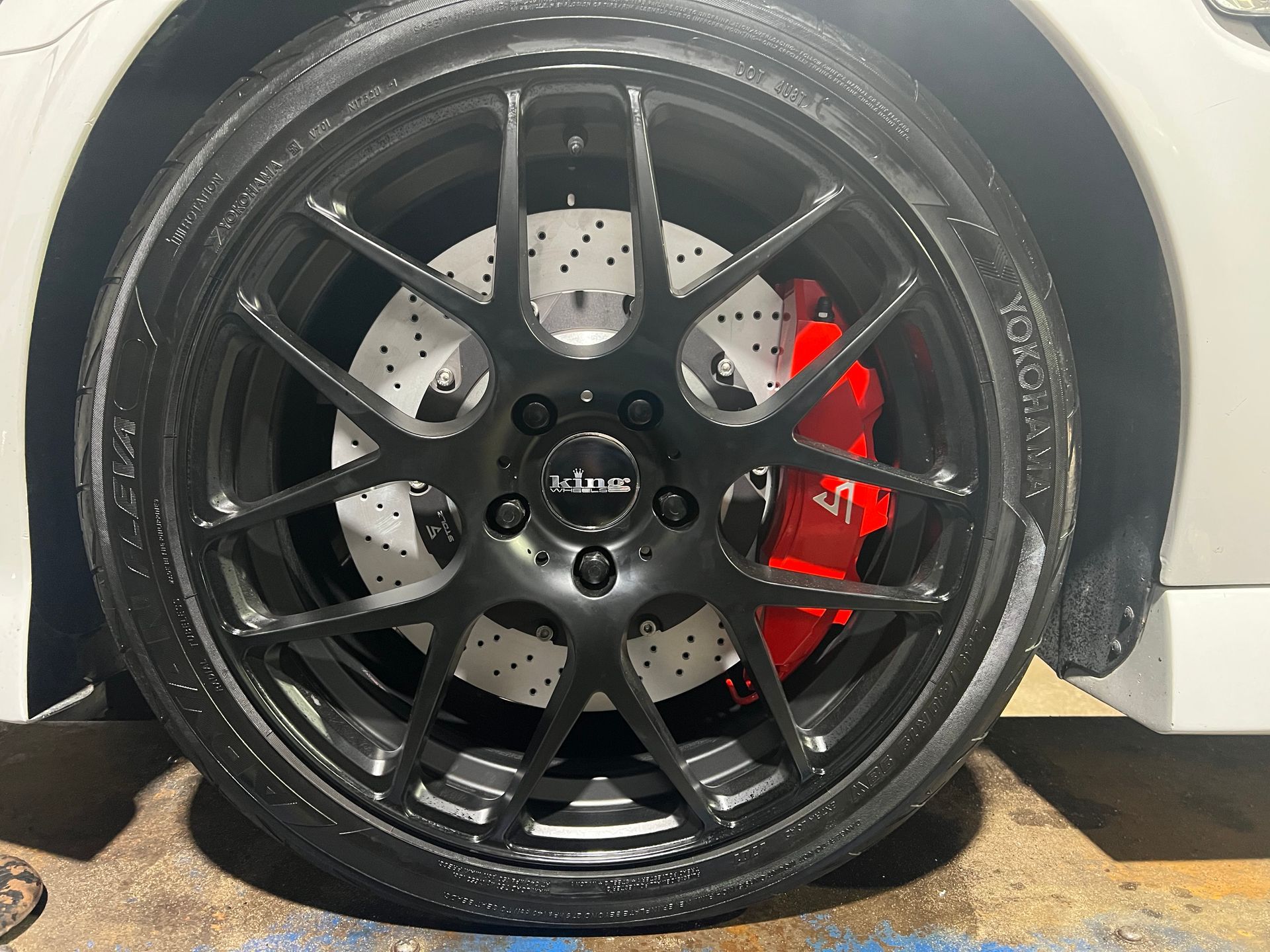 Black car wheel with a red brake caliper.
