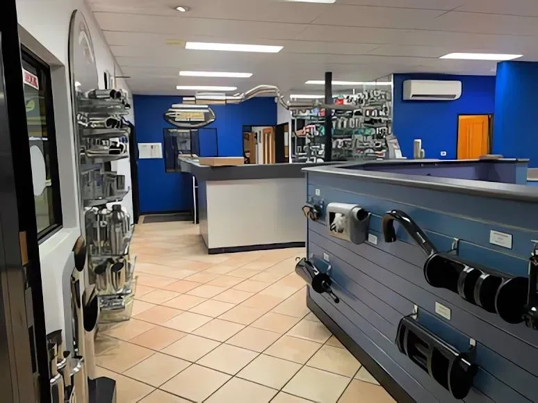 A Store With Beige Tile Floors, and Various Car Parts on Display — Carline Automotive and Exhausts in Belmont, NSW