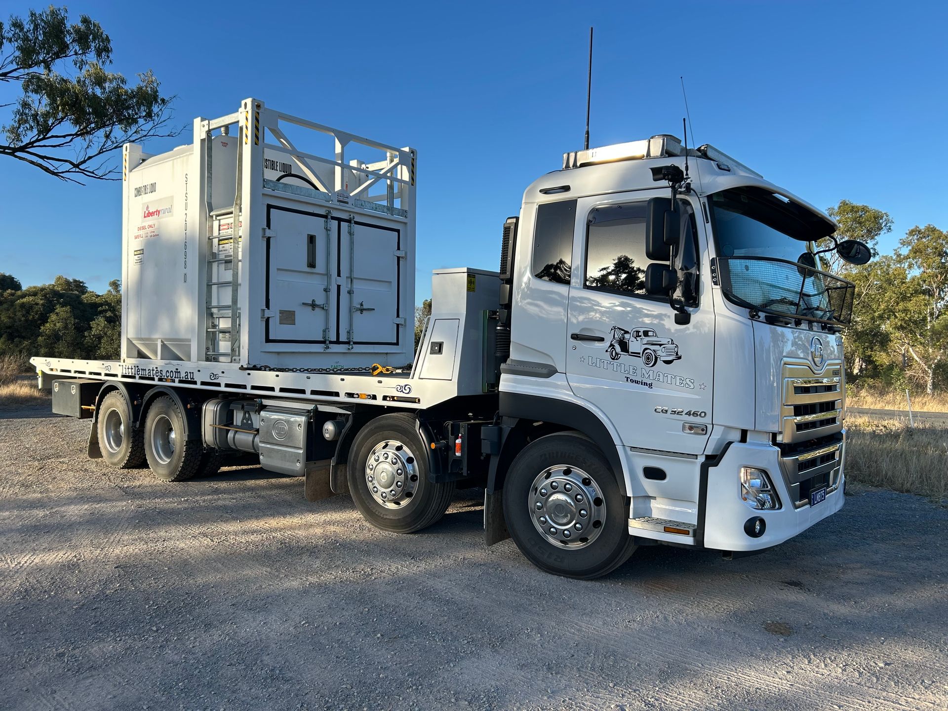 A Semi Truck Is Driving Down A Highway With A Car On The Back Of It — Little Mates Towing & Transport Pty Ltd In Yeppoon, QLD