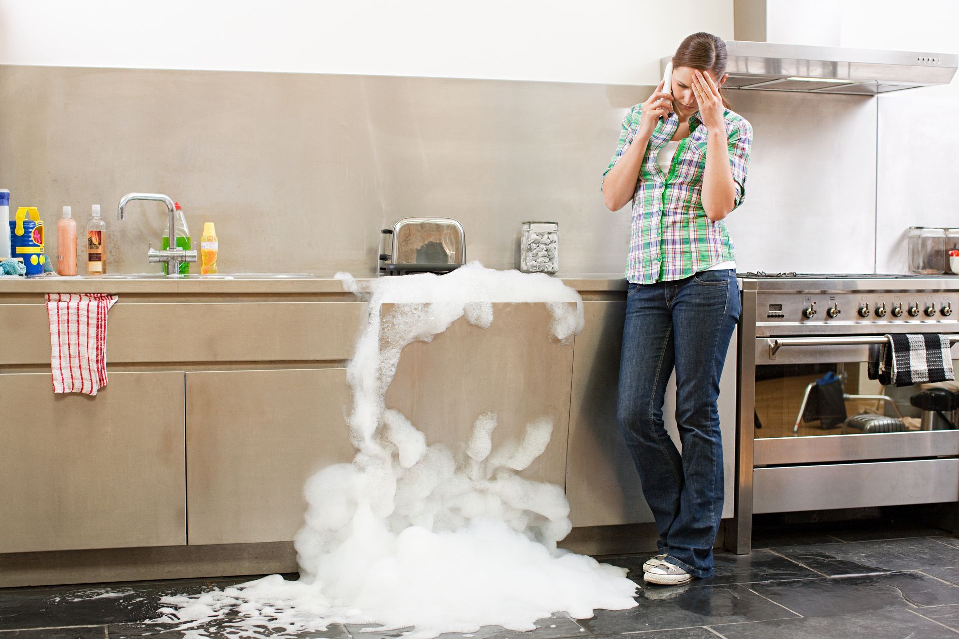 Dishwasher Overflowing And A Lady On A Phone - Appliance Repairs in Taree, NSW