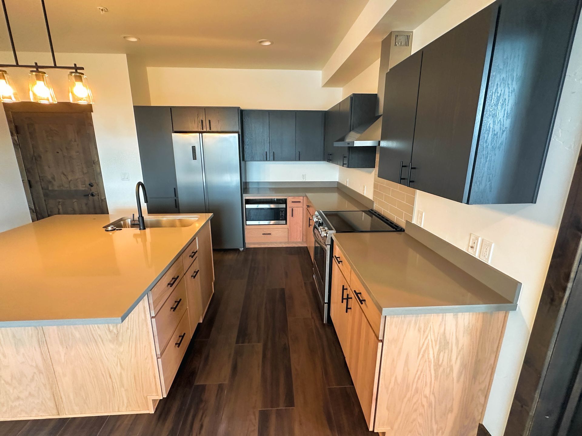 a kitchen with black cabinets and stainless steel appliances