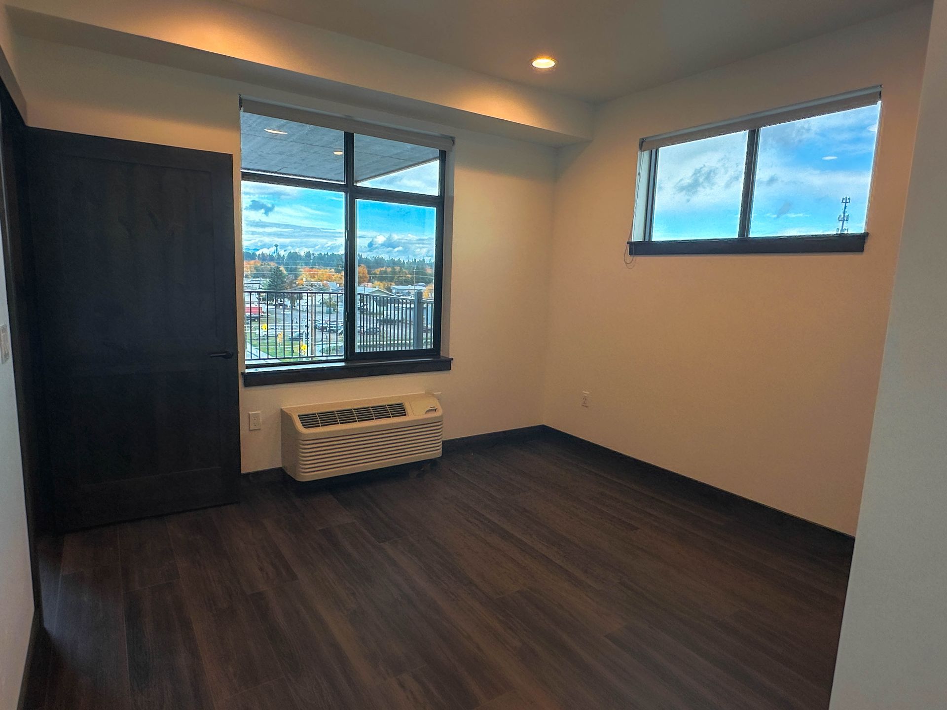 an empty room with a window and a small air conditioner