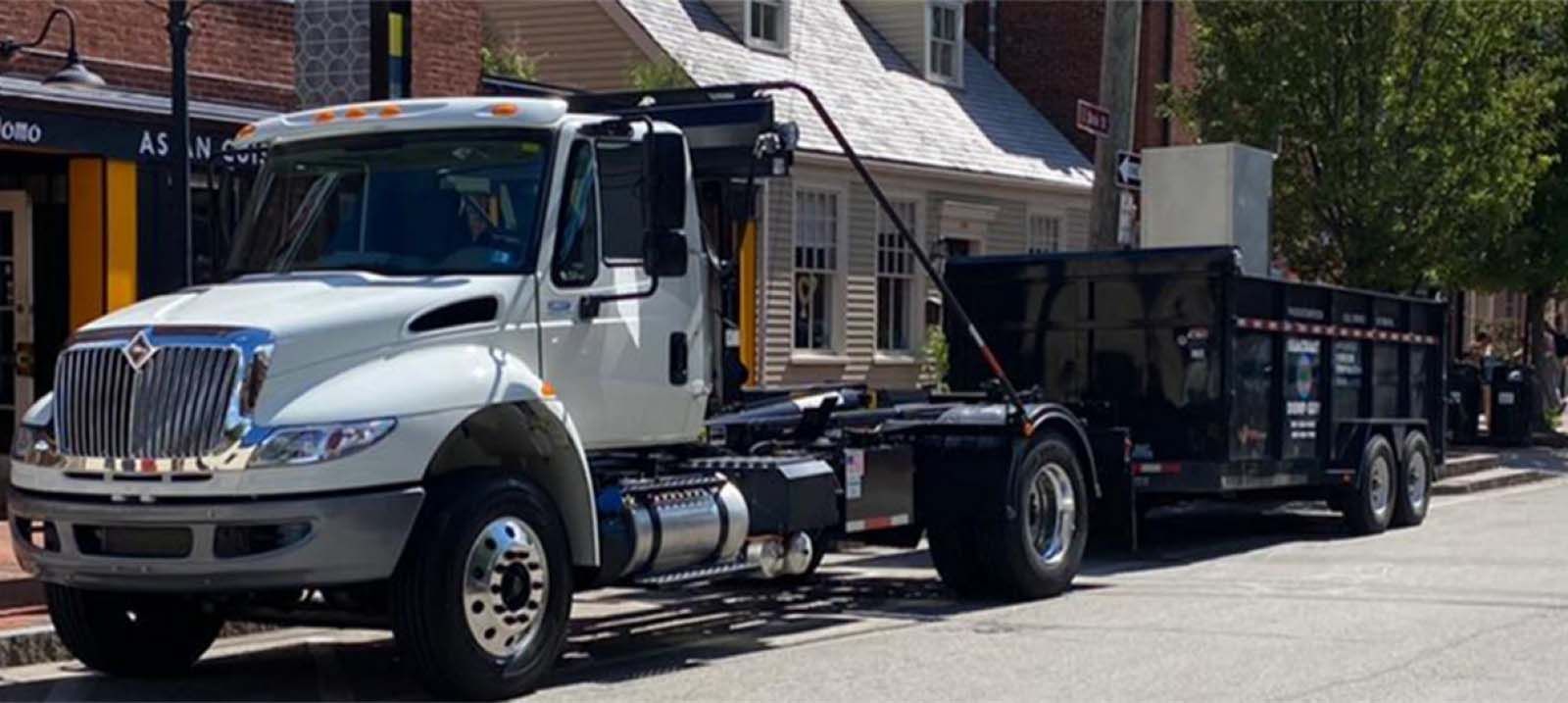 White International truck with black trailer parked on a city street.