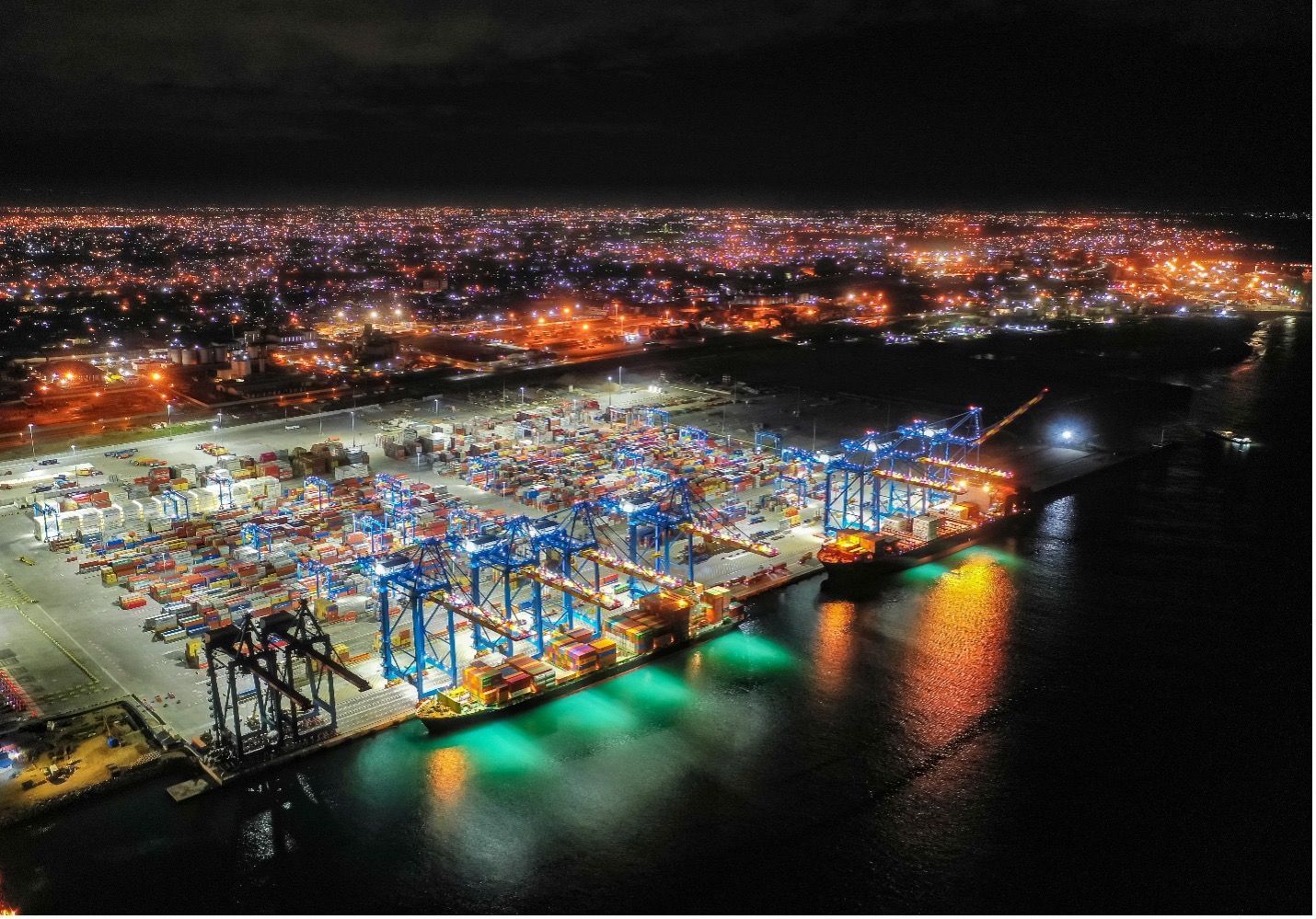 An aerial view of a large container port at night