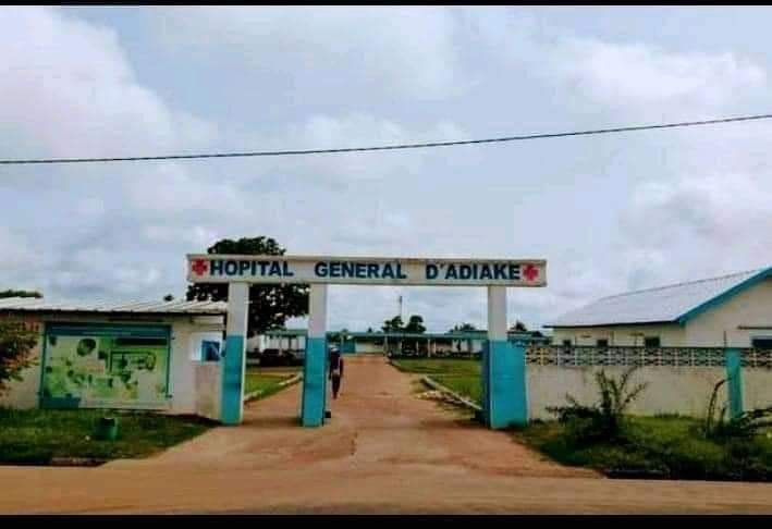The entrance to a hospital with a sign that says hospital general d' adiake