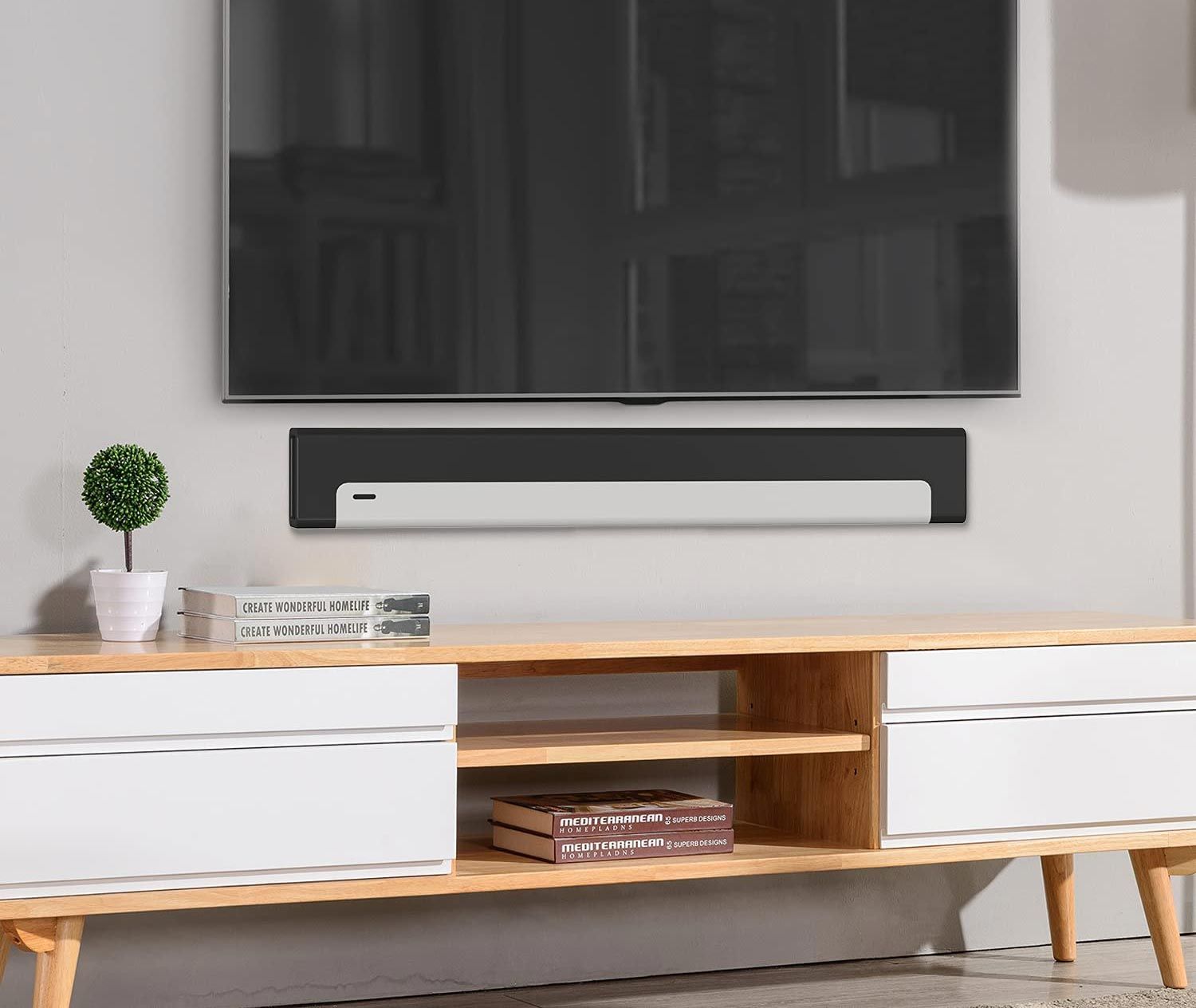 Soundbar mounted below a wall-mounted TV
