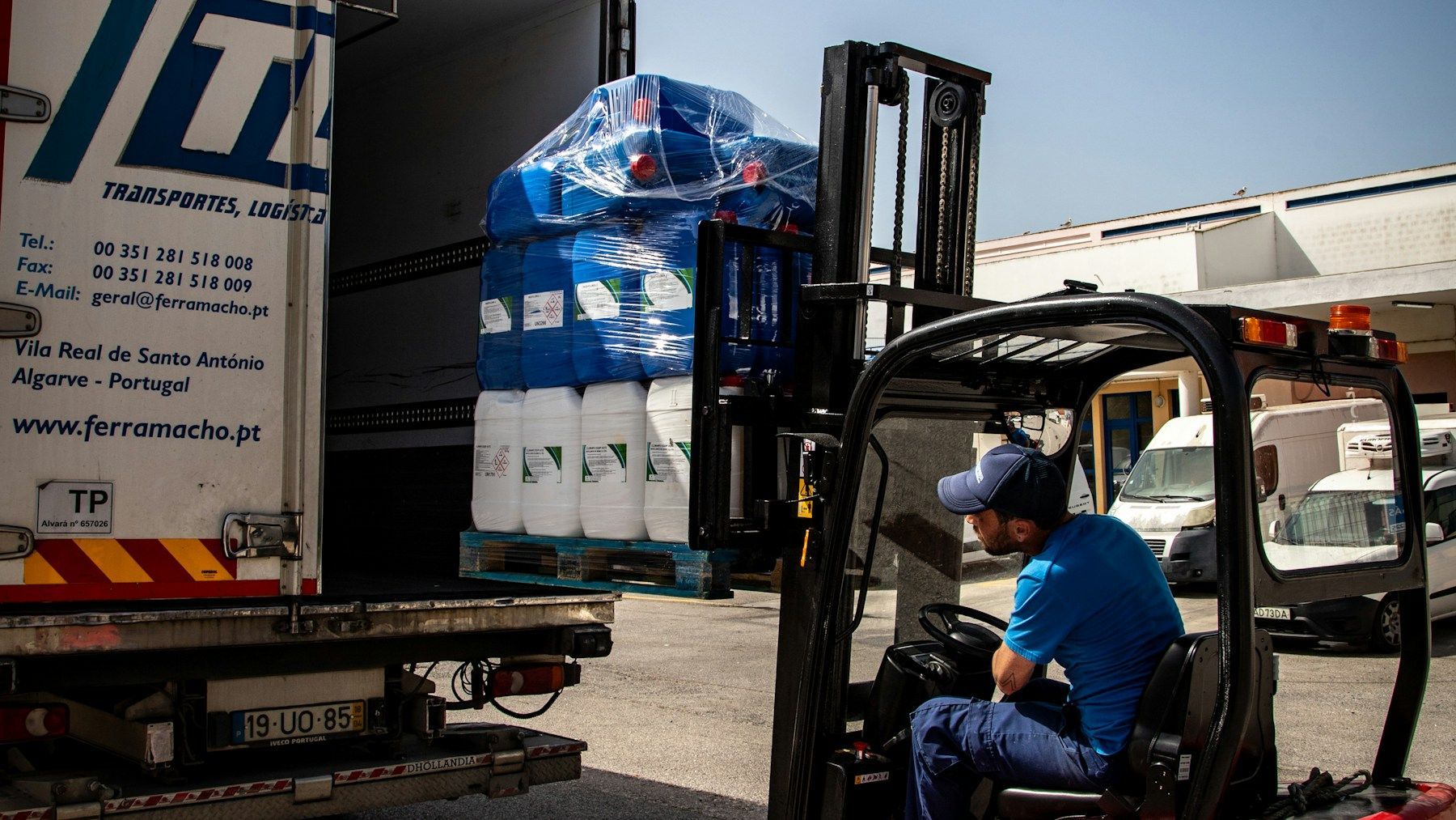 Forklift loading securely palletised commercial goods into a delivery truck