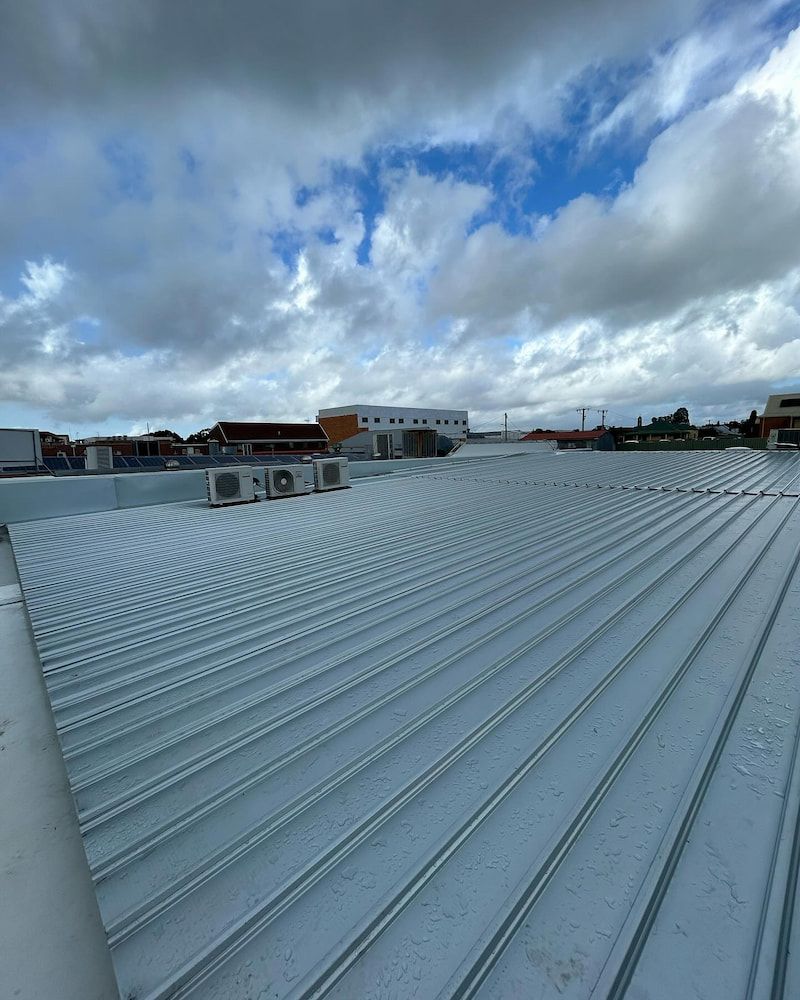 A Metal Corrugated Roof Under a Cloudy Sky — Ace1 Metal Roofing in Taree, NSW