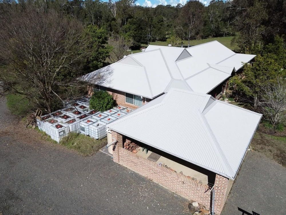 An Aerial View of a Brick House With a White Metal Roof — Ace1 Metal Roofing in Taree, NSW